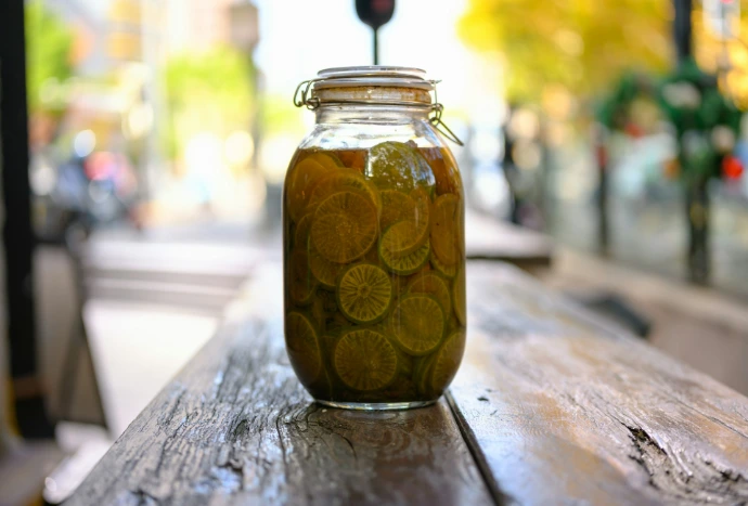 A jar of pickles sitting on top of a wooden table